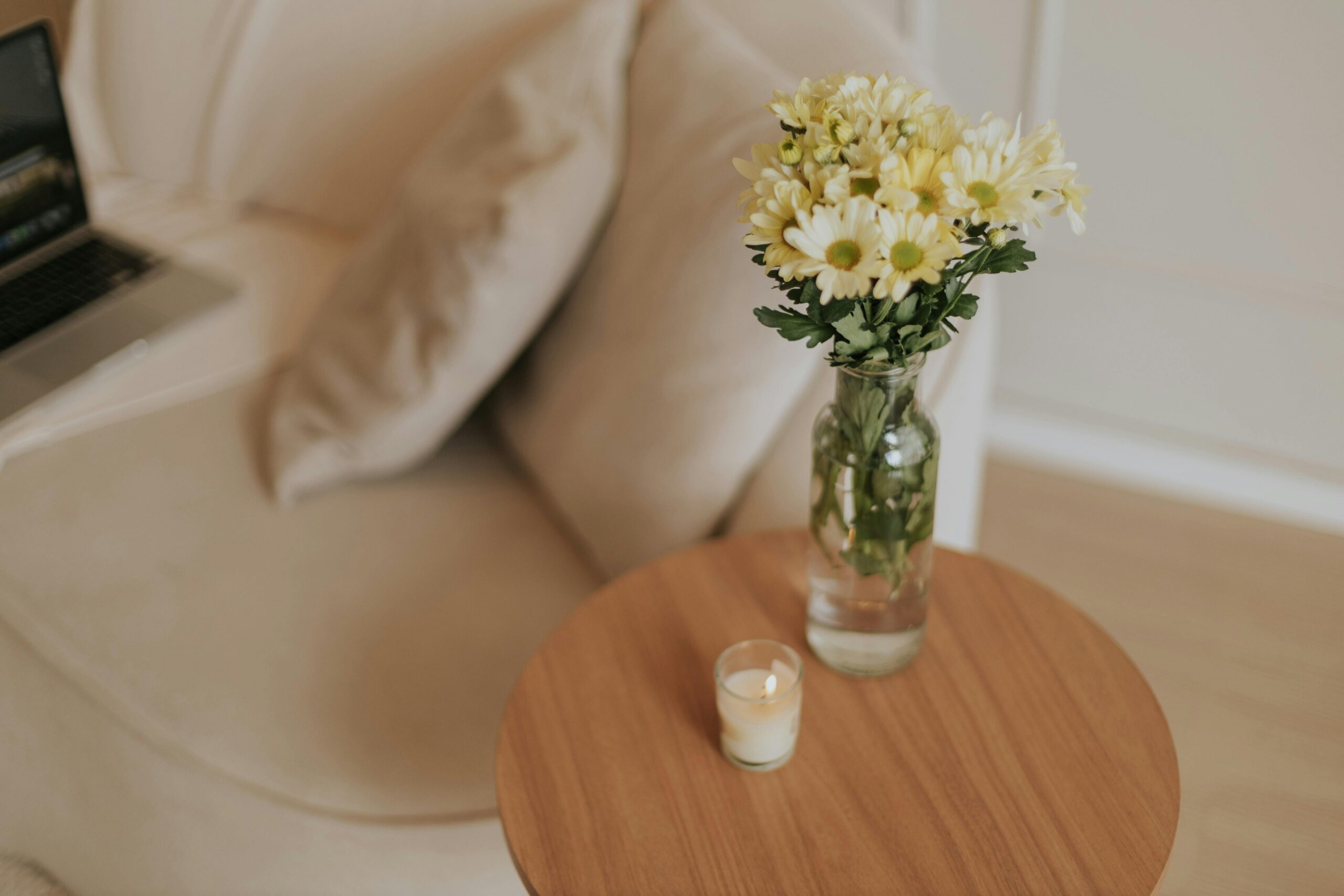 calm home neutral sofa and vase of yellow flowers